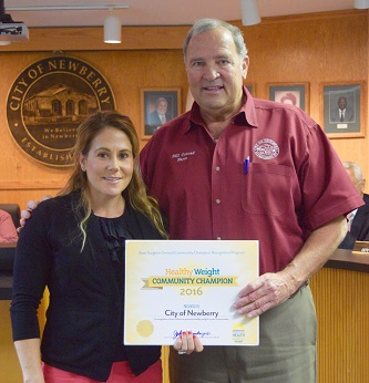 FDOH Alachua Healiest Weight Coordinator Kourtney Oliver presents City of Newberry Mayor Bill Conrad with Community Champion Recognition Award 