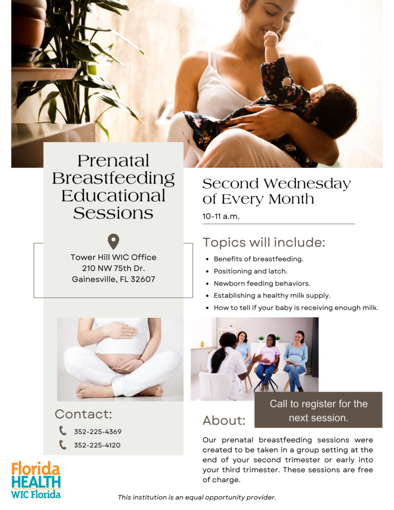 A person holds a baby wrapped in a floral print outfit, with a potted plant in the background.